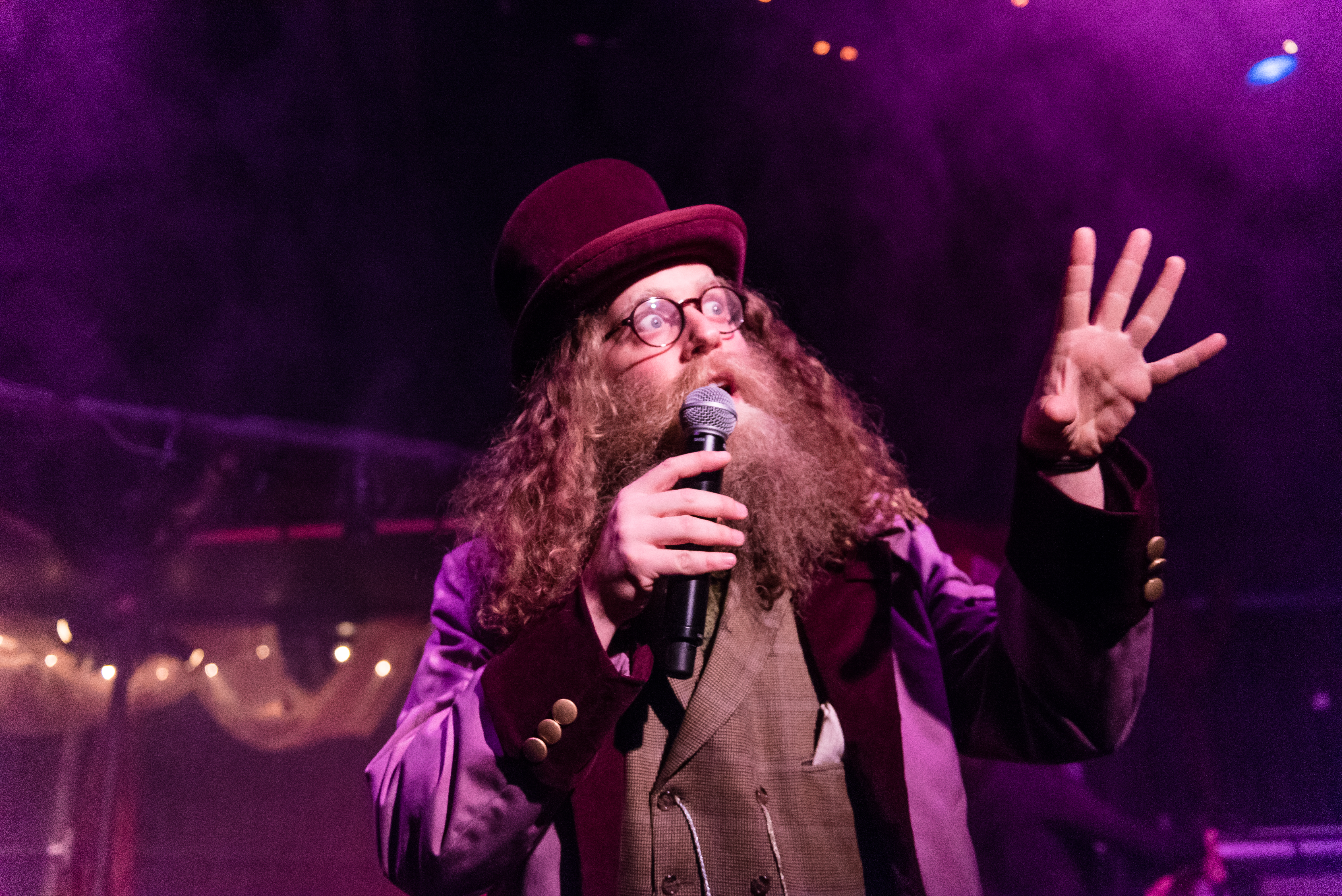 Ben Caplan speaking into a microphone looking out at an audience