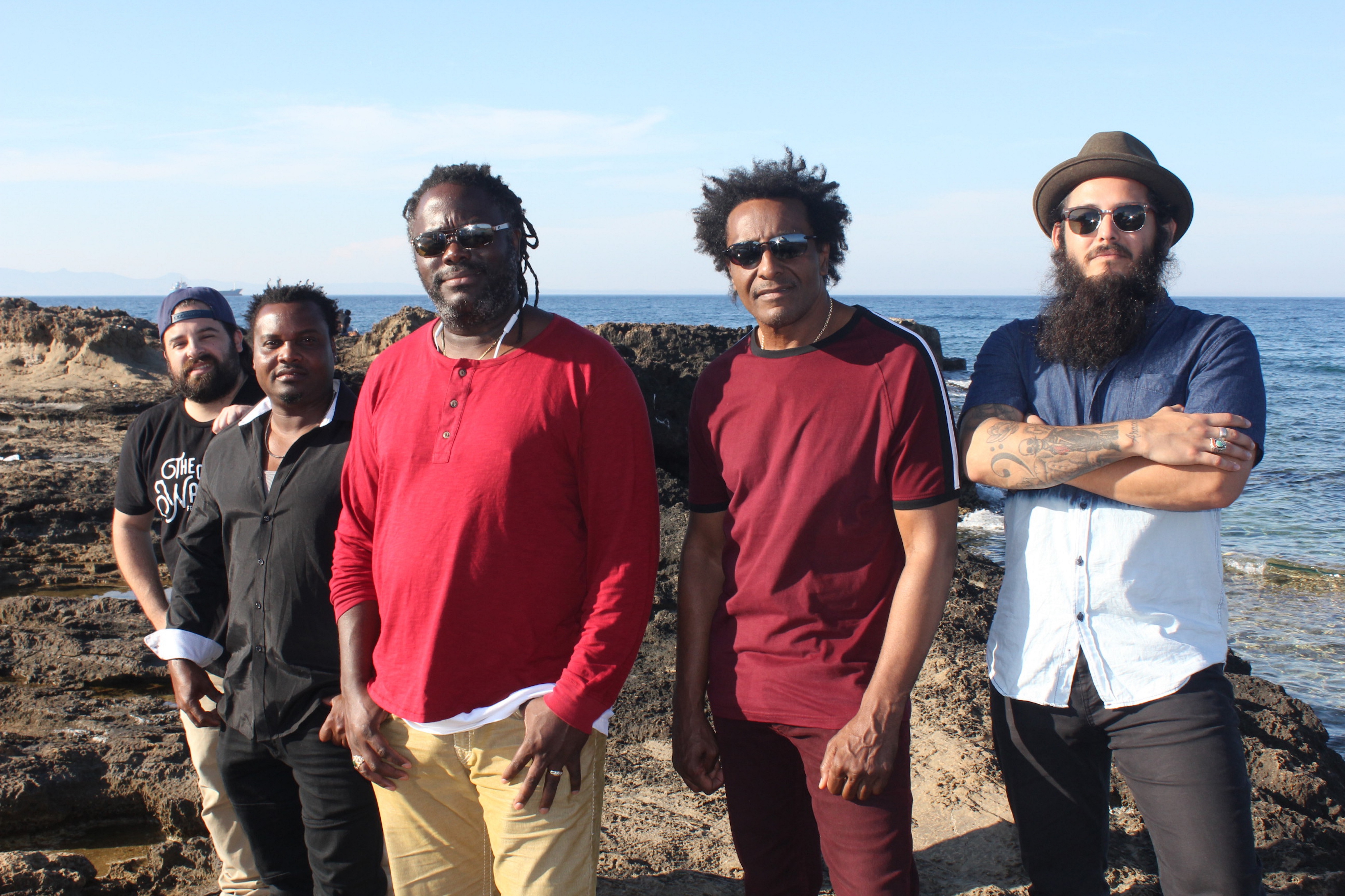 5 members of The Original Wailers standing in front of the ocean