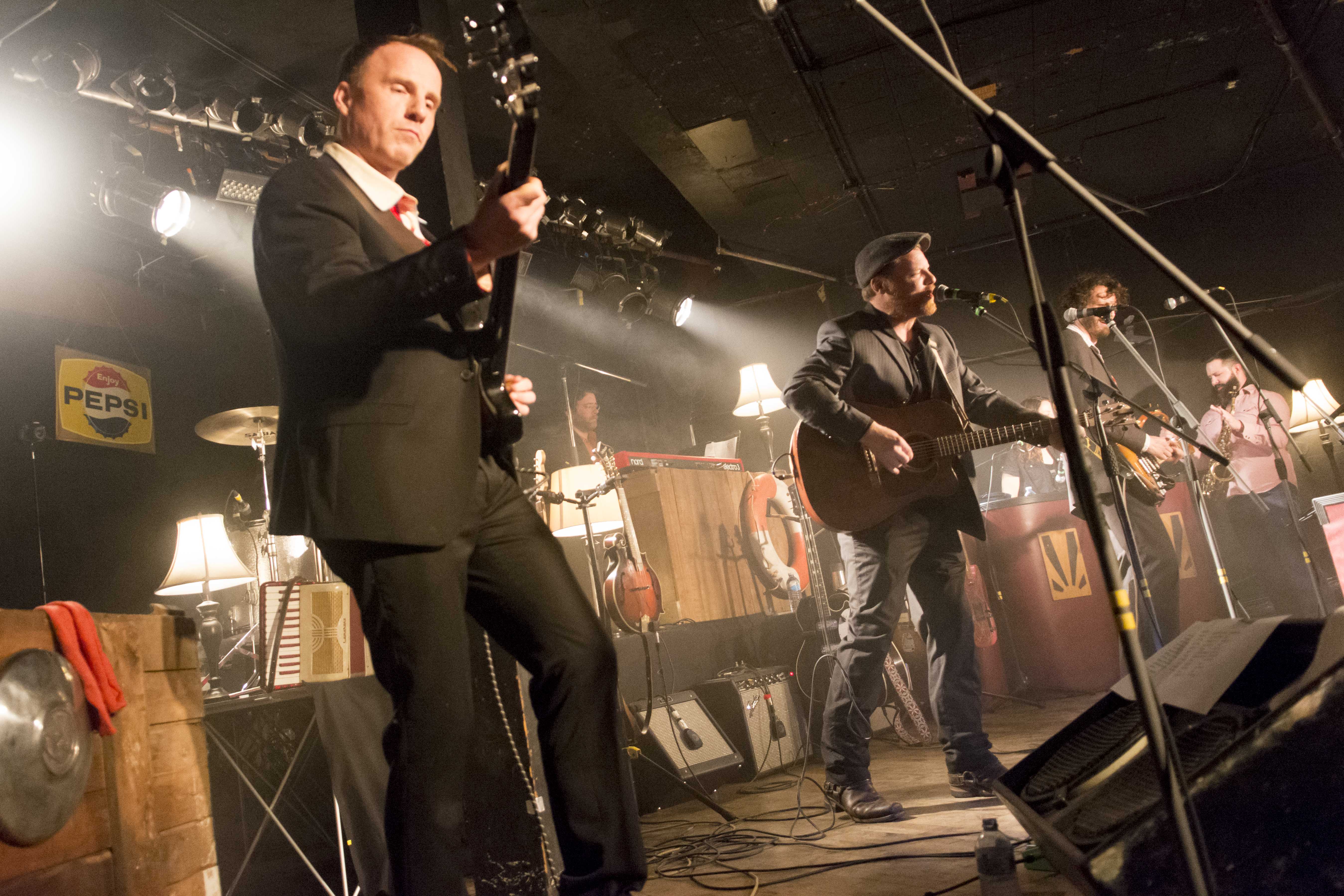 Close up of a guitar player on stage with a band