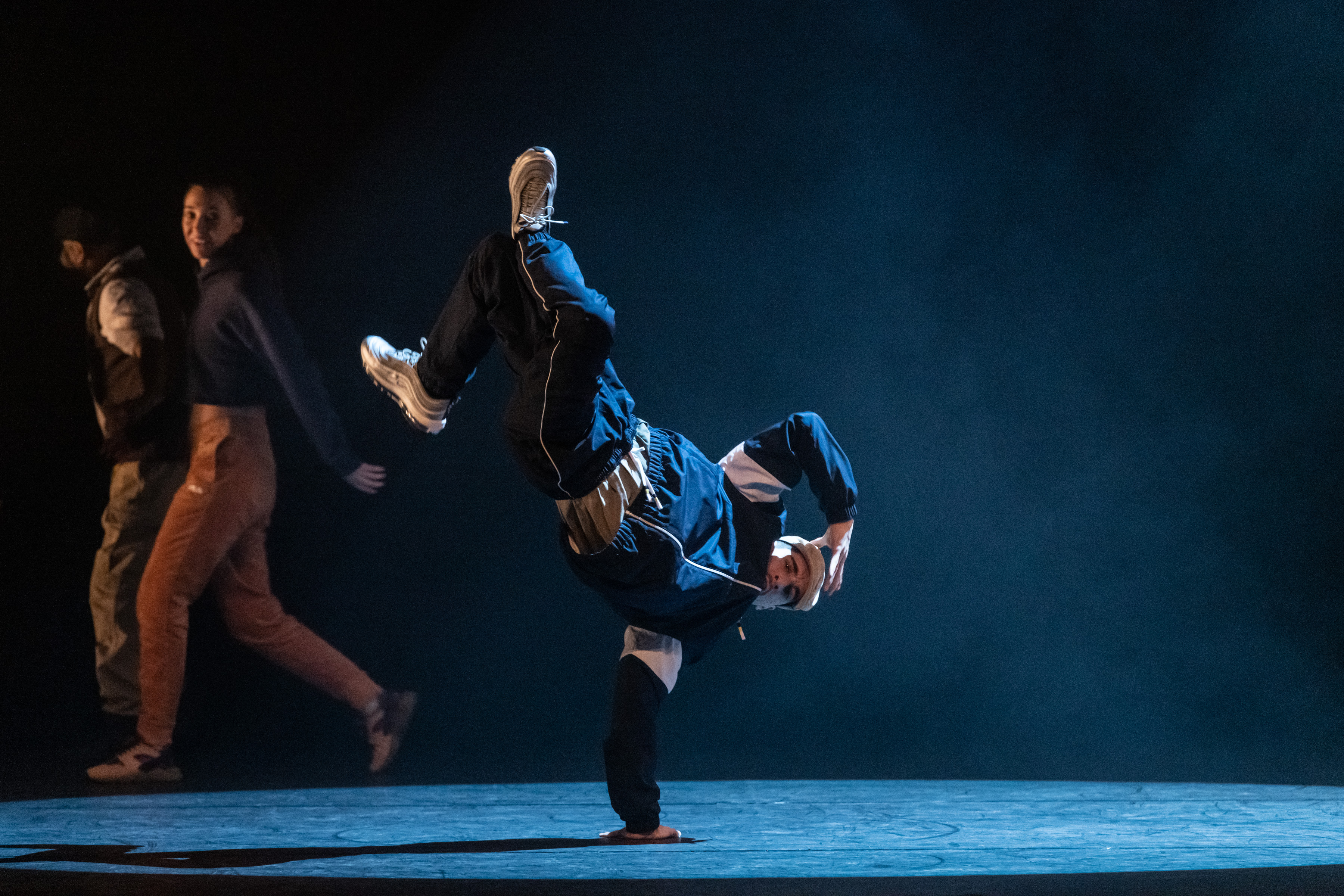 A breakdancer doing a single-arm handstand