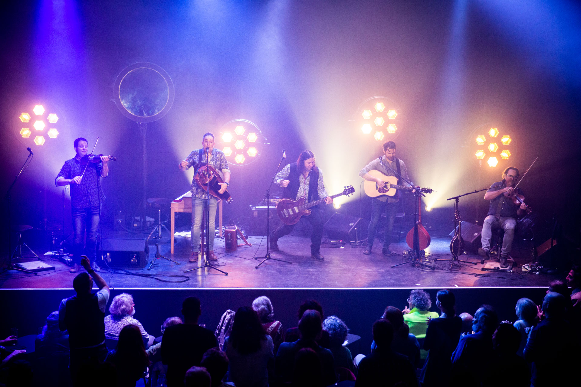 The five members of le Vent du Nord are playing their instruments on stage