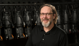 Jonathon Best in a black shirt against a black stage backdrop