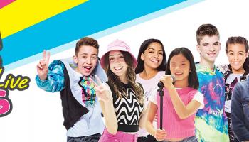 A group of children posing, one with a microphone. The words Mini Pop Kids Live to the left.