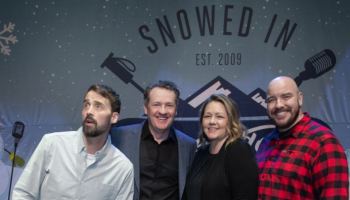 Four comedians standing on stage with the Snowed In Comedy Tour backdrop behind them.