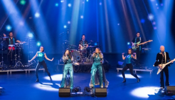 A group dressed as ABBA performing on stage.