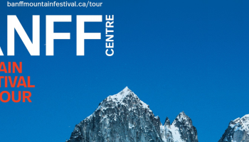Blue sky and mountain tops with the words BANFF Centre Mountain Film Festival on the left or the mountain tops.