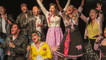The cast of Bear Grease the Musical strike poses on a city street.