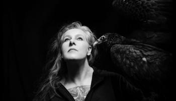 Neko Case faces the sky with a vulture on her shoulder