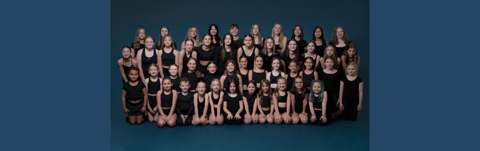 X-treme Dance company photo over a dark blue background. 