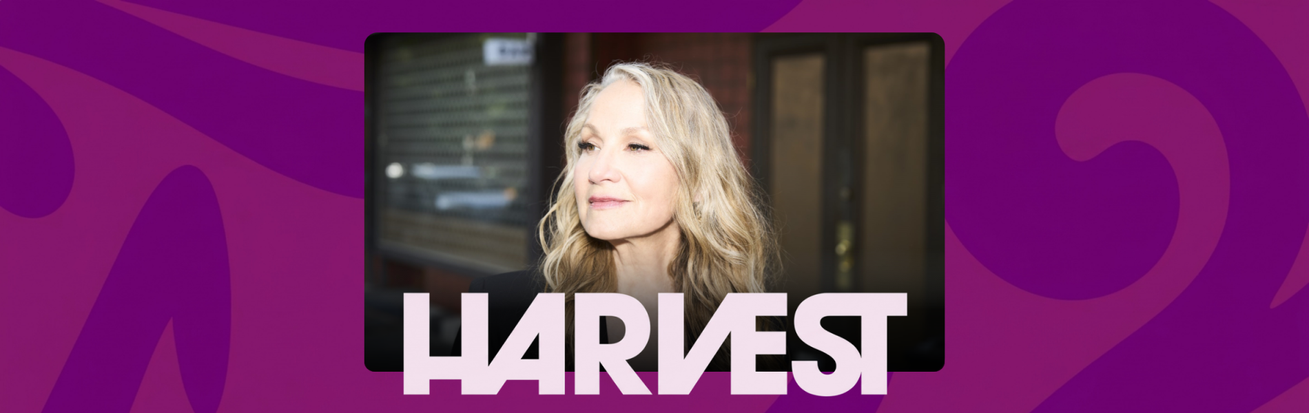 An image of Joan Osborne centered over a pink and purple background. The word HARVEST in light purple below Joan's image.