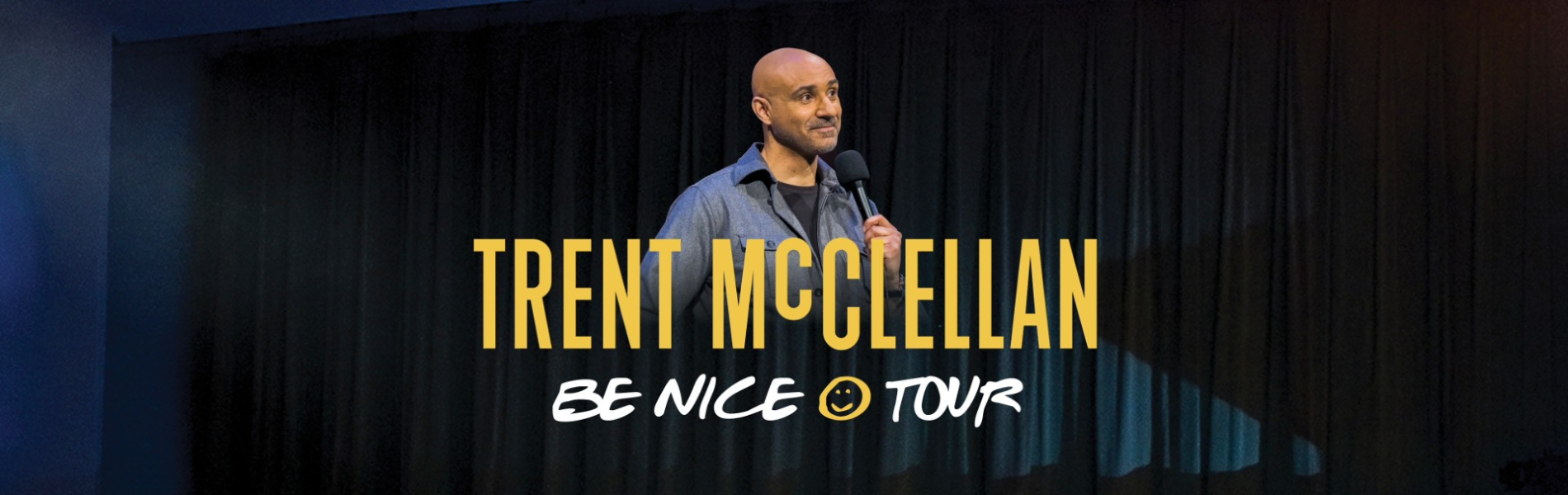 An image of Trent McClellan smiling and holding  a microphone. The words, 'Trent McClellan Be Nice Tour' in yellow and white lettering.