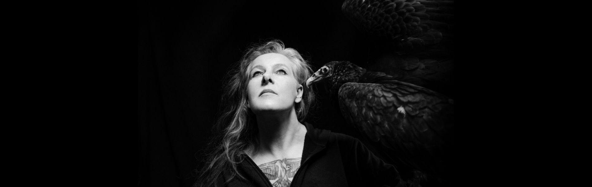 Neko Case faces the sky with a vulture on her shoulder