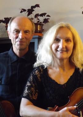 Aida and Hrvoje Tisler standing beside each other holding violins