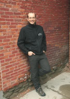 Brent Staeben standing in front of a brick wall